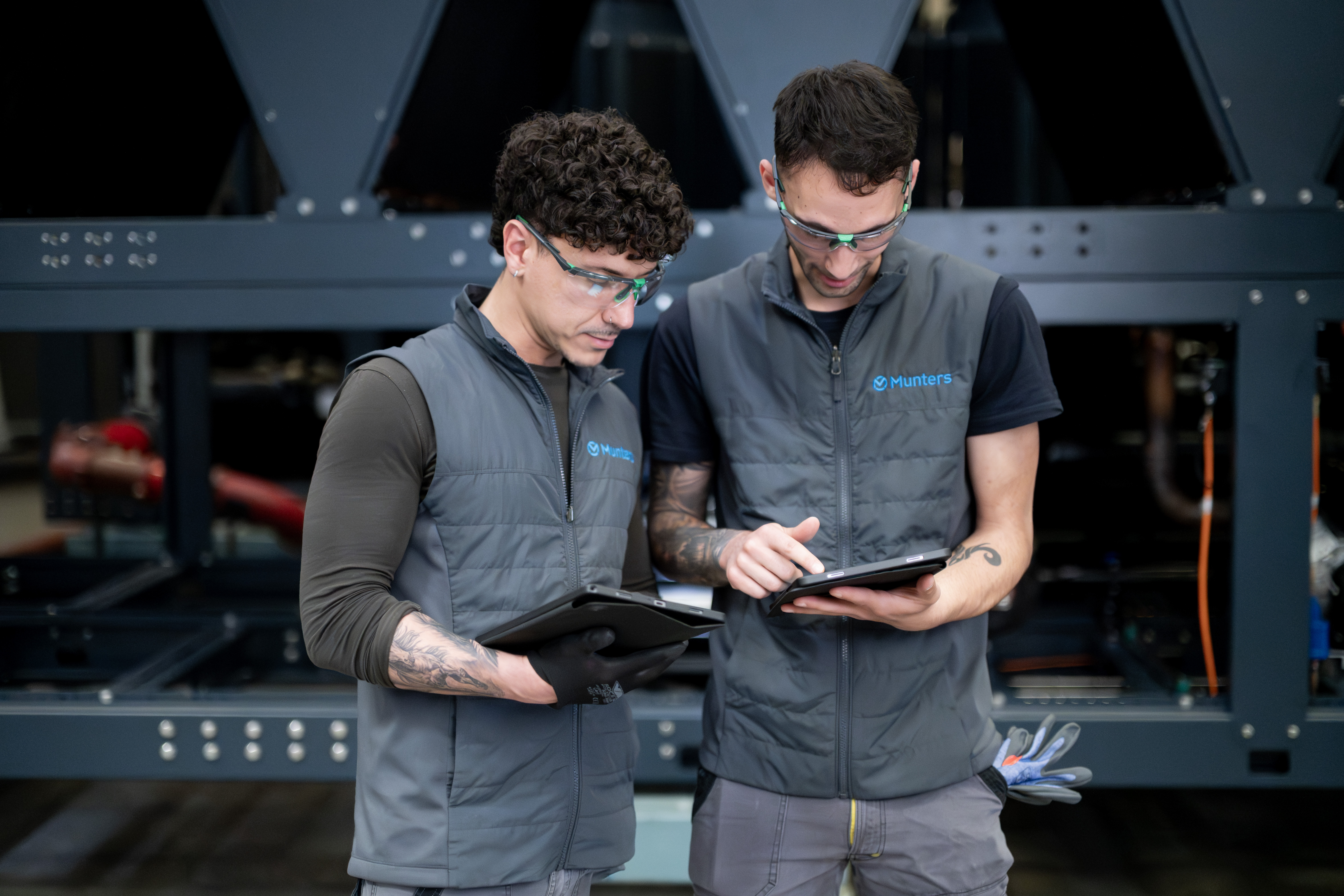 Munters technicians reviewing equipment data on tablets at an industrial facility