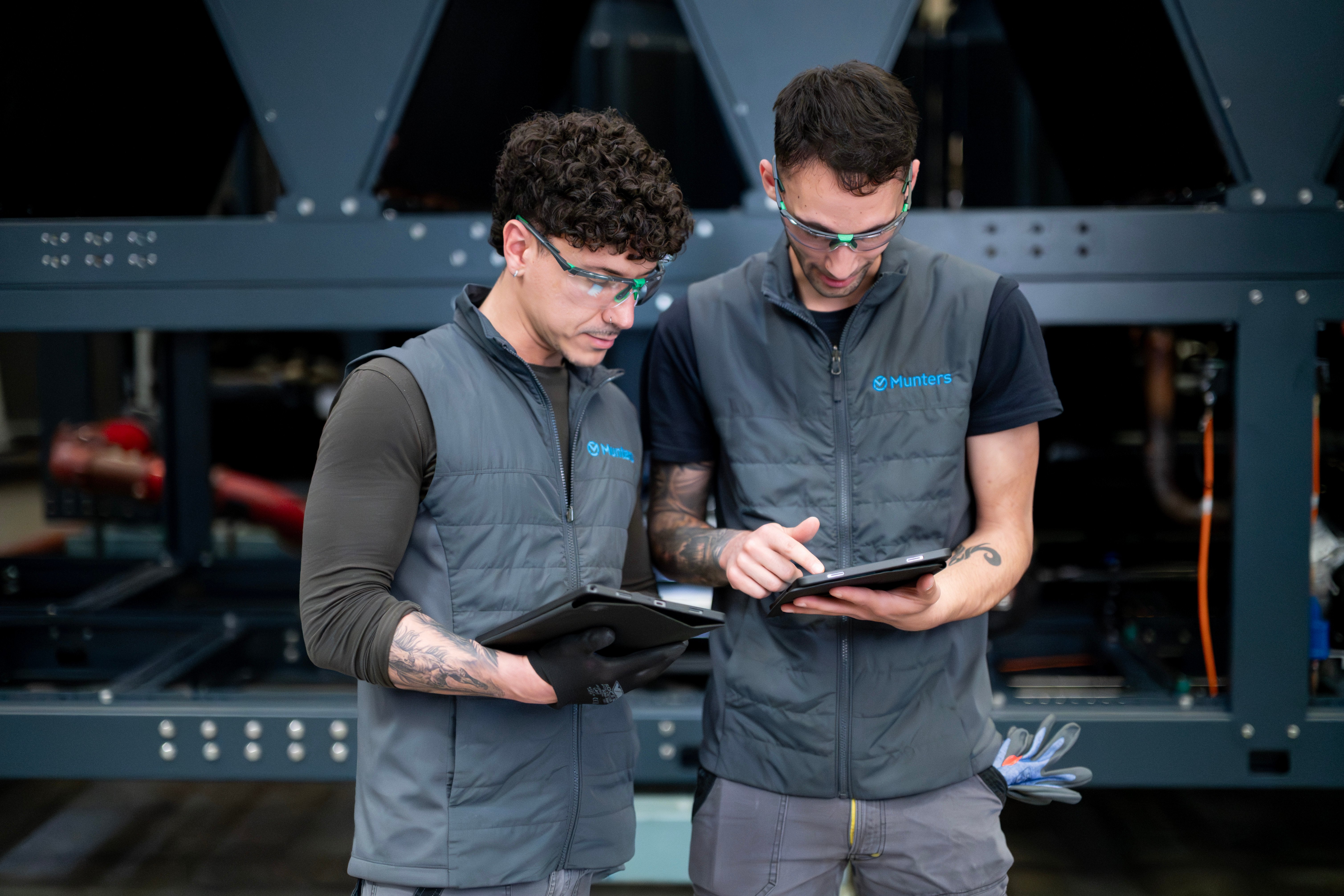 Munters technicians reviewing equipment data on tablets at an industrial facility