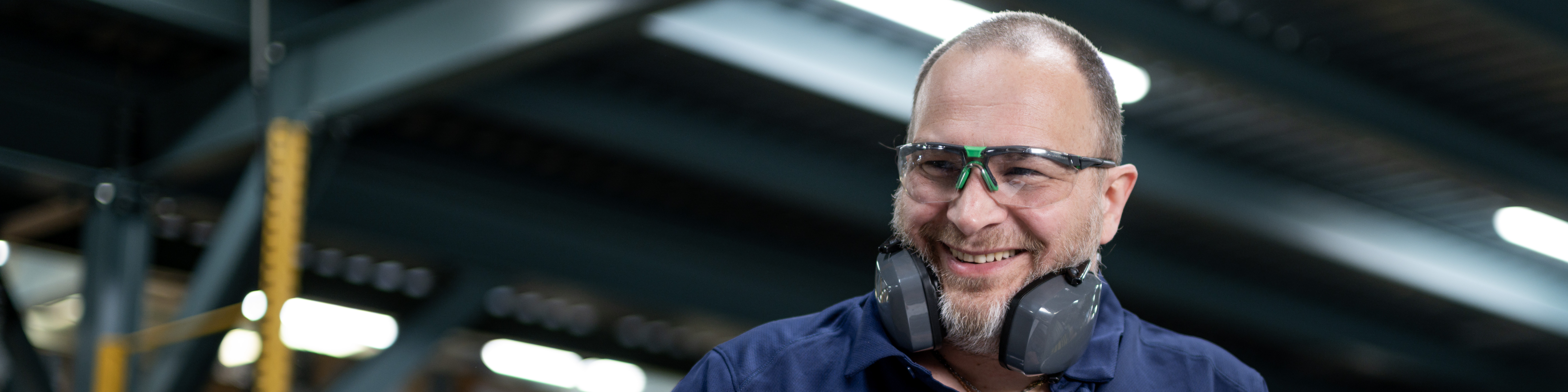 Munters employee wearing safety glasses and hearing protection in a manufacturing facility