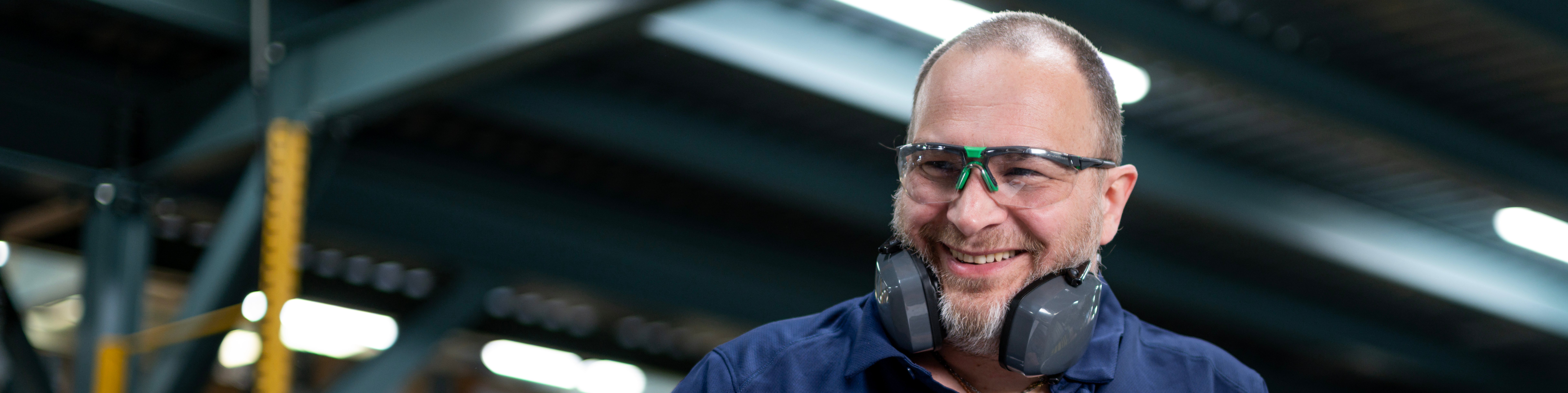 Munters employee wearing safety glasses and hearing protection in a manufacturing facility